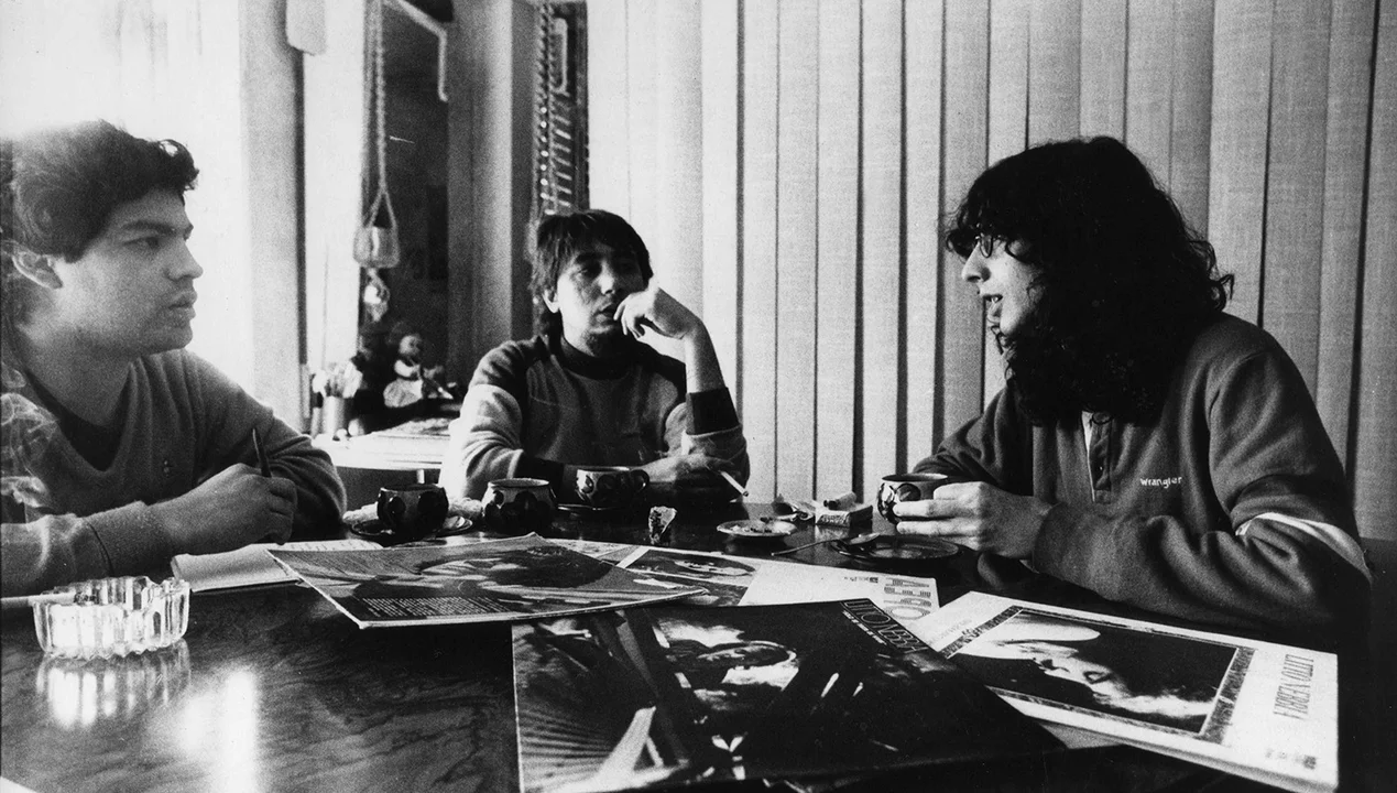 Imagen de otro tiempo. A la derecha, Fito Páez de 20 años. En el centro, Lalo de Los Santos, el dueño de casa. Sobre la mesa, discos de Litto Nebbia. A la izquierda, el autor de esta nota. 1983.